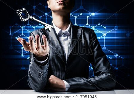 Cropped image of businessman in suit keeping big key in hand with network connections on background.