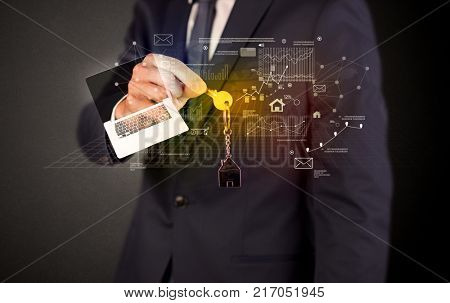 Businessman in suit holding keys with statistics, graphs and icons around