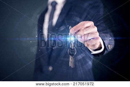 Businessman in suit holding over a key with connection concept around
