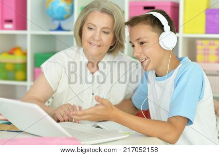 granny with her grandson using laptop at home