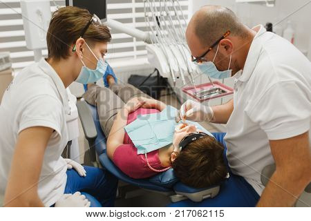 Close Up Process Of Preparing And Installing Dental Ceramic Crown. Male Professional Dentist Helps T