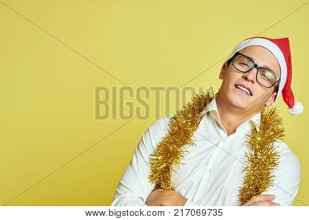 man in glasses and a white shirt, yellow tinsel, free space for copying, new year, portrait.