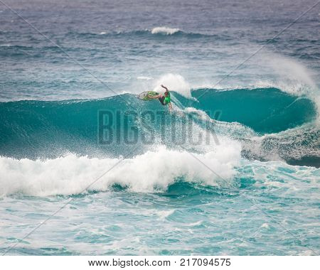 SUNSET BEACH HAWAII USA - DECEMBER 2, 2017: Competitive surfer at the 2017 Vans World Cup of Surfing competition at Sunset Beach on Oahu's scenic North Shore. This is the second of three surfing competitions and Conner Coffin took first place.