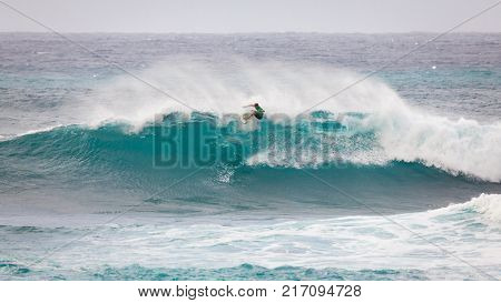 SUNSET BEACH HAWAII USA - DECEMBER 2, 2017: Competitive surfer at the 2017 Vans World Cup of Surfing competition at Sunset Beach on Oahu's scenic North Shore. This is the second of three surfing competitions and Conner Coffin took first place.