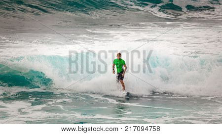 SUNSET BEACH HAWAII USA - DECEMBER 2, 2017: Competitive surfer at the 2017 Vans World Cup of Surfing competition at Sunset Beach on Oahu's scenic North Shore. This is the second of three surfing competitions and Conner Coffin took first place.