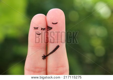 Fingers art of happy couple. Man kisses woman on cheek.