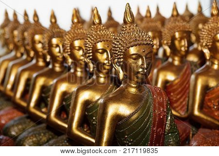 Gold Buddha statues sitting in row on white background. Statues in Buddhist Thailand temple or wat are public domain or treasure of Buddhism no restrict in copy or use.