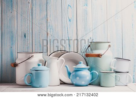 Enamelware on the kitchen table over blue wooden wall