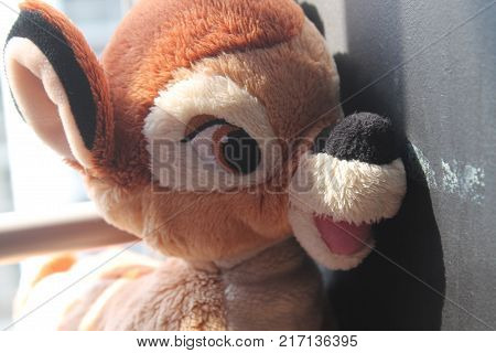 Bear and fawn toy sitting by the window in shadows