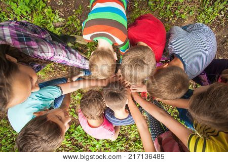 Close-up of many children's hands holding together as a team on a nature background