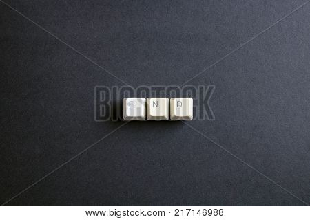 The end. Flat lay view from above on the table with computer keyboard keys buttons on a dark background.