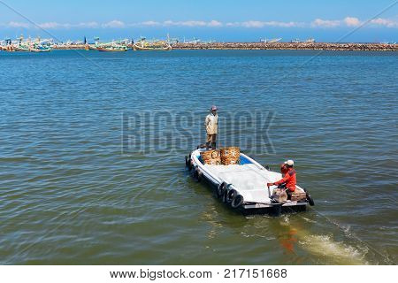Jembrana Bali Island Indonesia - September 20 2015: A way of life earning money in Bali. In Perancak fishing village Indonesian harbour dockers take the ice to traditional fishing boats