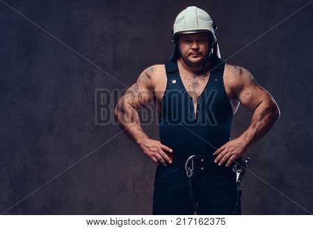 Brutal firefighter dressed in underwear waistcoat and white firefighter helmet.