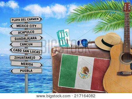 Concept of summer traveling with old suitcase and Mexico town sign