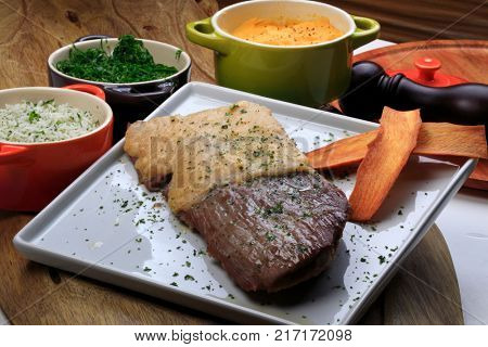 Roasted meat with rice, farofa and kale