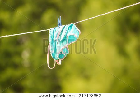 Blue child's swimsuit hanging on white chaise
