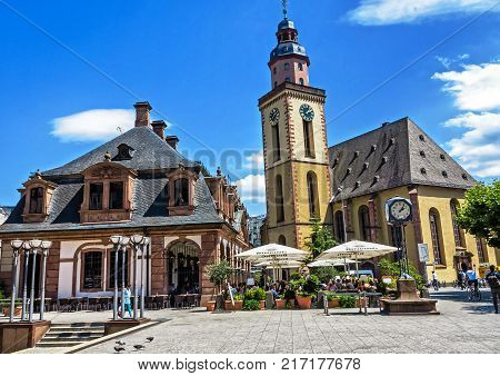 FRANKFURT, GERMANY-JULY 21, 2017: The historic Café Hauptwache (popular meeting place since its opening over 100 years ago) and St. Katharine church in the middle of the city