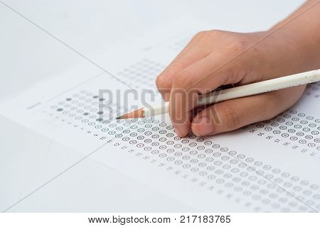 woman's hands filling in standardized test form