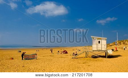 Lifeguard house and holidaymakers on Camber Sands Beach, East Sussex, England, April 2017