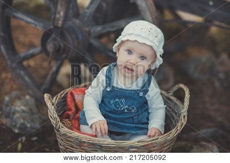 Baby Girl With Ocean Deep Blue Eyes And Pinky Cheek Wearing White Shirt And Jeans Dress And Handmade