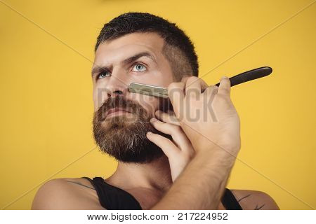 Fashion and beauty innovation. Barber and hairdresser. Haircut of bearded man archaism. Man cut beard and mustache with razor. Serious hipster in barbershop new technology.