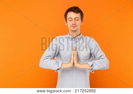 Young Adult Man Closed Eyes And Prays.