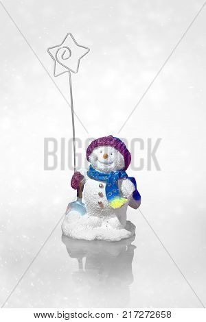 smiling snowman holds the star of bethlehem on a blue snow light gray illustration background