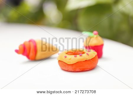 Doughnut made from playdough on table against blurred background, closeup