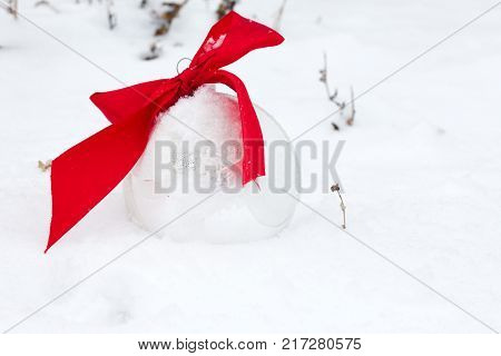 silver Christmas balls with red ribbon on snowbackground