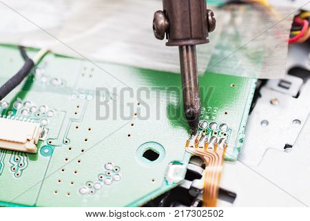 repairing of electric circuit board with soldering iron close up