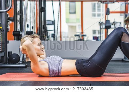 young sportive woman doing hyperextension exercise on gym machine