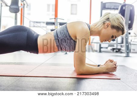 young sportive woman doing hyperextension exercise on gym machine