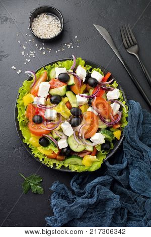 Greek salad in ceramic plate on gray concrete background. Traditional Greek dish. Selective focus.Top view.