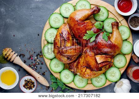 Chicken tabaka served on a wooden plate with vegetables