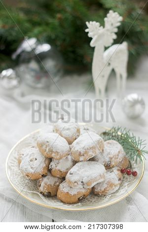Mini Stollen or Stollen candy in the background with a deer figure, Christmas balls and fir branches. Selective focus.