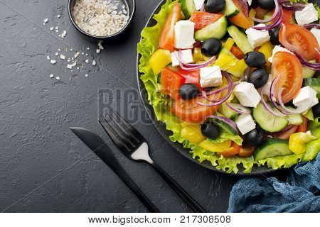 Greek salad in ceramic plate on gray concrete background. Traditional Greek dish. Selective focus.Top view.