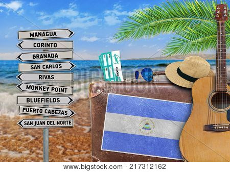 Concept of summer traveling with old suitcase and Nicaragua town sign