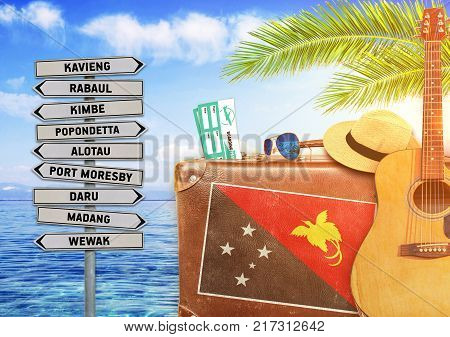 Concept of summer traveling with old suitcase and Papua New Guinea town sign