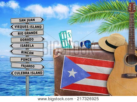 Concept of summer traveling with old suitcase and Puerto Rico town sign