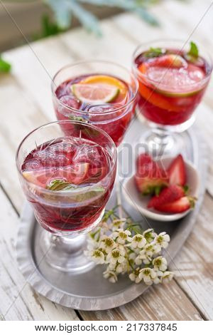 cold refreshing cocktails cranberry flavoured red wine sangria drinks for a spring summer party with fresh strawberries
