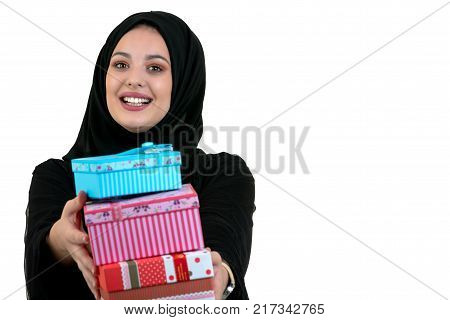 Happy young muslim woman with shopping bag and gift boxes isolated over white background.