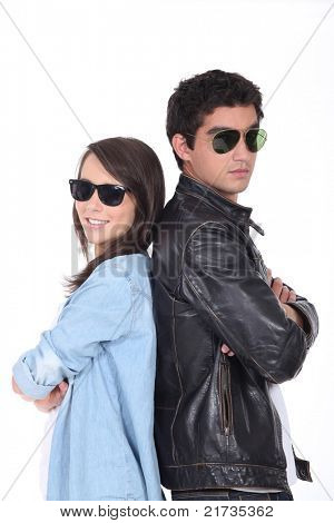 Jovem casal sendo cool de óculos escuros e jaqueta de couro