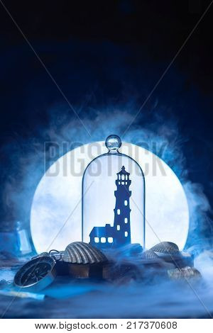 Sea still life with lighthouse silhouette in full Moon. Night ocean scene with smoke on water and copy space. Conceptual paper craft.