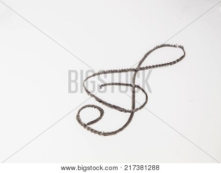Painted cosmetic eye pencil treble clef on white background.