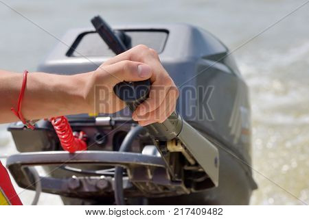 Fisherman hand driving and boat engine, close up