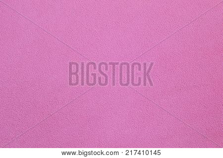 The blanket of furry pink fleece fabric. A background texture of light pink soft plush fleece material