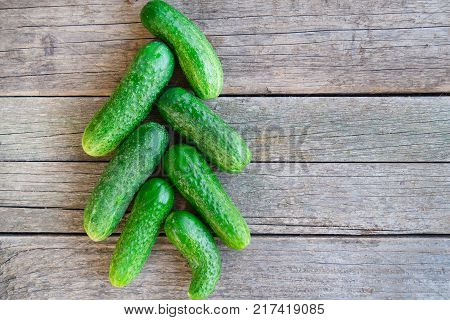Green cucumbersl are arranged in the form of a Christmas tree on the wooden table