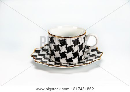 Porcelain cup and saucer with a chess piece on a white background. For coffee and tea.