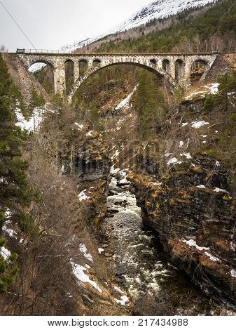 Arch stone bridge Kylling over Rauma river, Verma in Romsdalen in Norway, april 2017