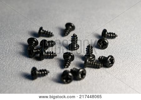 small scattered screws scattered on gray cloth